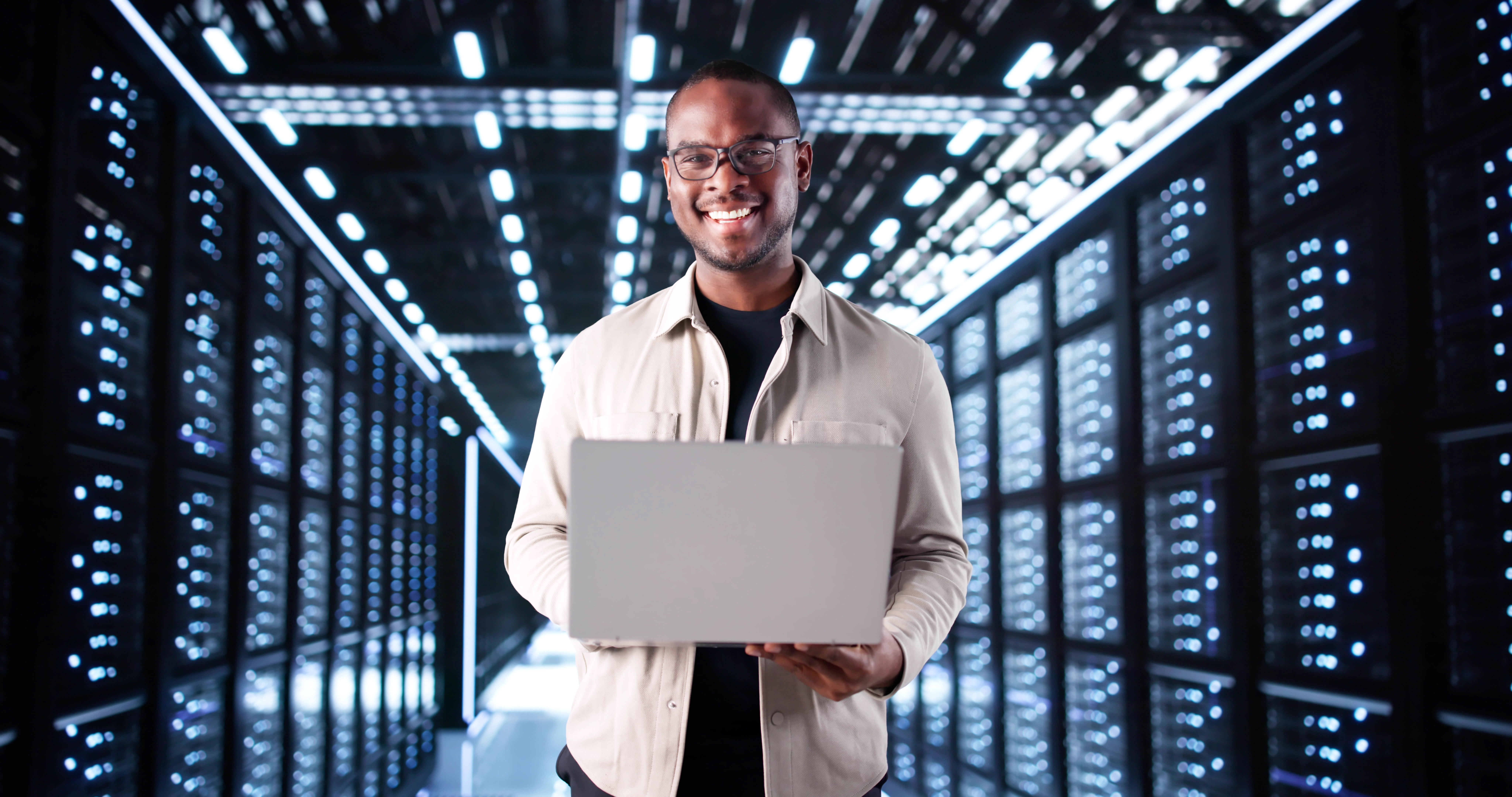 Portrait of a male network engineer in a high-tech server room, representing reliable data storage and cloud computing solutions.