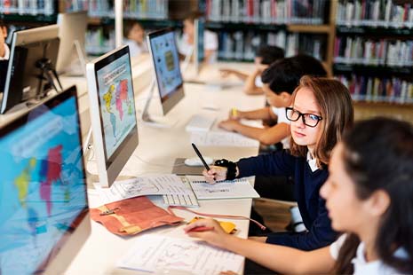 School children in classroom working at compuuters