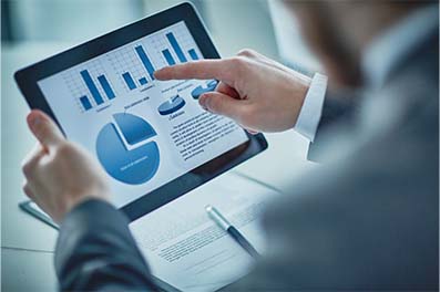 Person holding tablet with data charts on screen