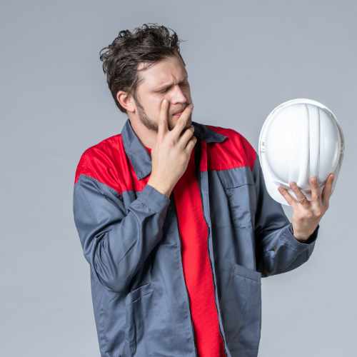 Worker looking at helmet thinking