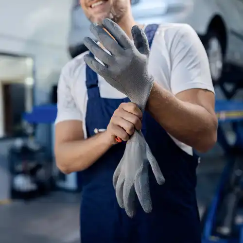 Worker putting on safety gloves