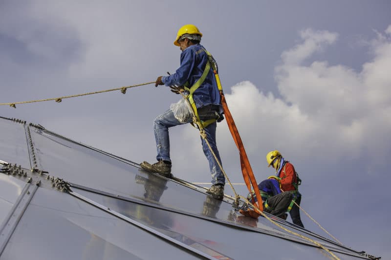 Construction worker on rooftop wearing fall protection equipment