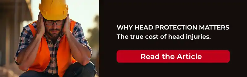 Construction worker wearing a hard hat and high visibility clothing squatting down with a head injury