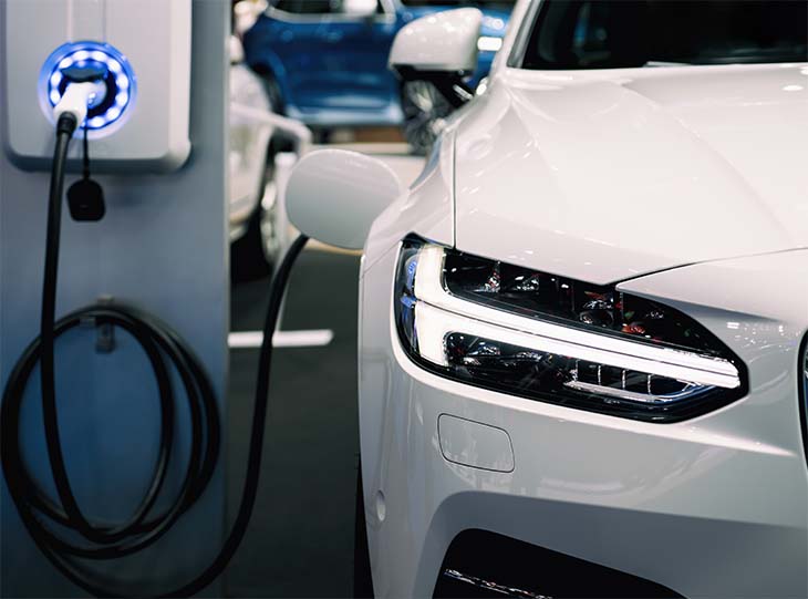 White Electric Car Plugged Into Charge Point