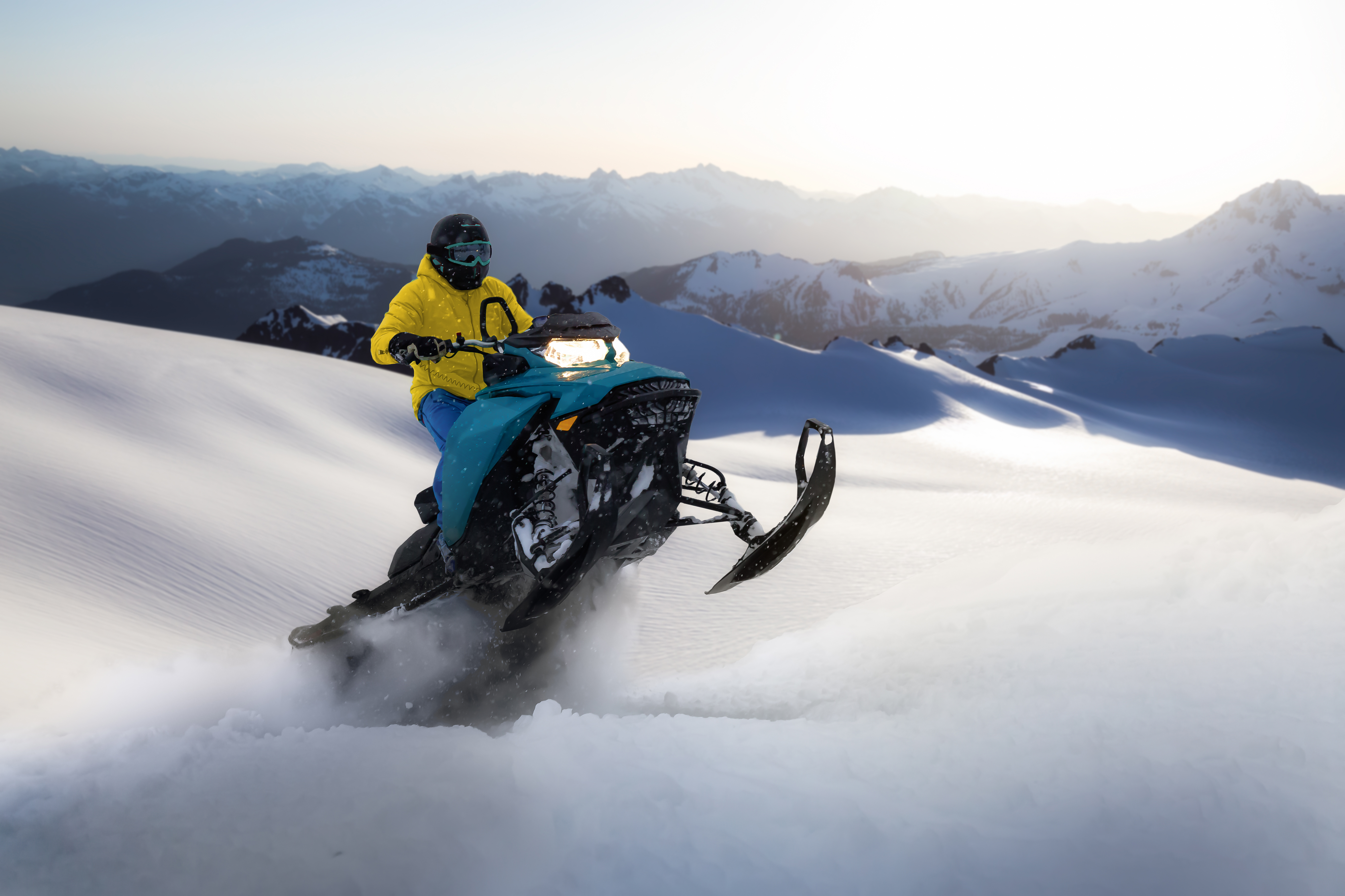 Person on a snowmobile in the air after going off a jump in the snow