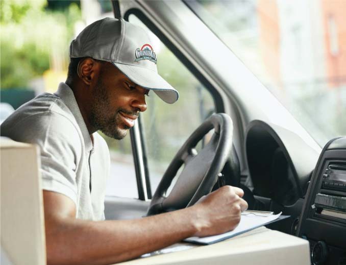 GCE employee in vehicle, writing on clipboard