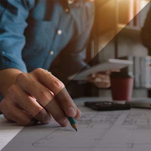 Person with pencil creating architectural design