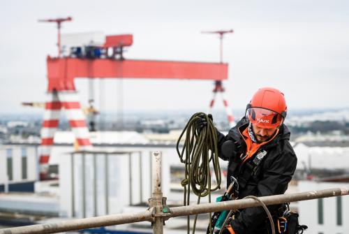Worker wearing KASK Zenith X2 Type II Class E safety helmet during construction work at height with fall protection gear