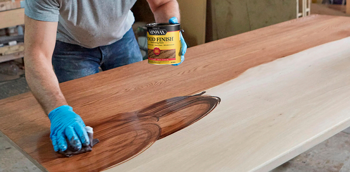 a man applying minwax stain