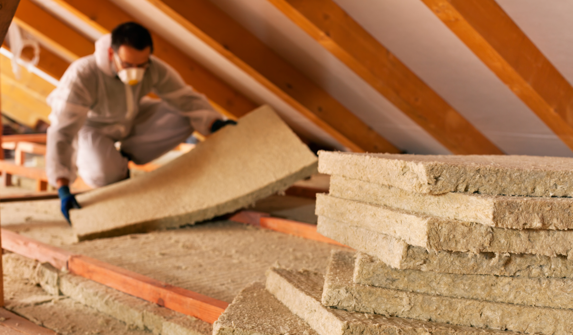a man installs RockWool insulation in an attic