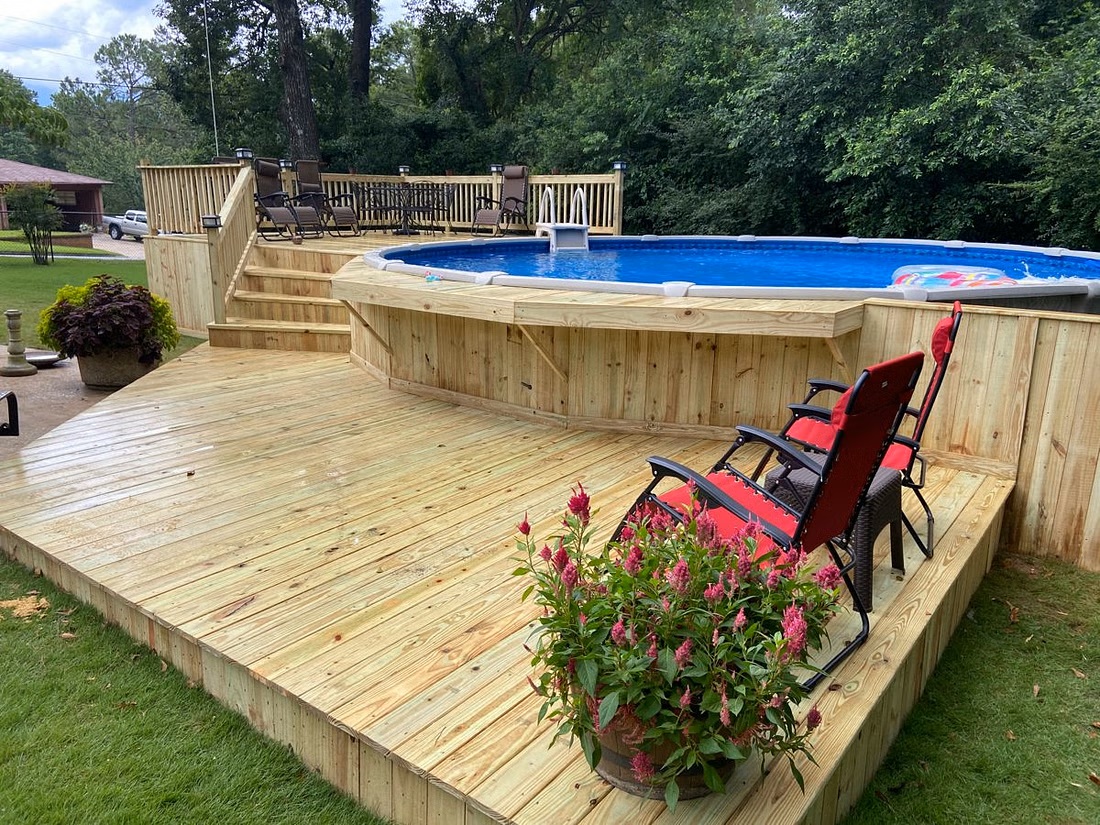 a pool in a back yard with a deck around it.
