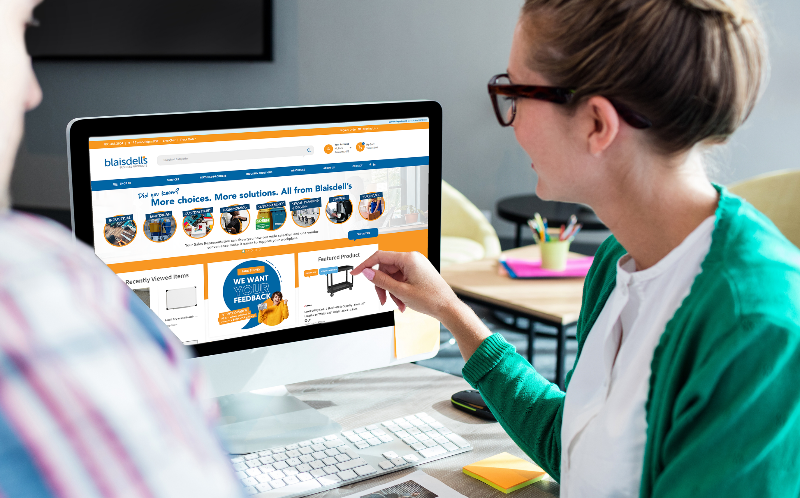 Professional office manager organizing supply orders at desk with computer, calculator, and office supplies, representing streamlined purchasing processes for Bay Area businesses