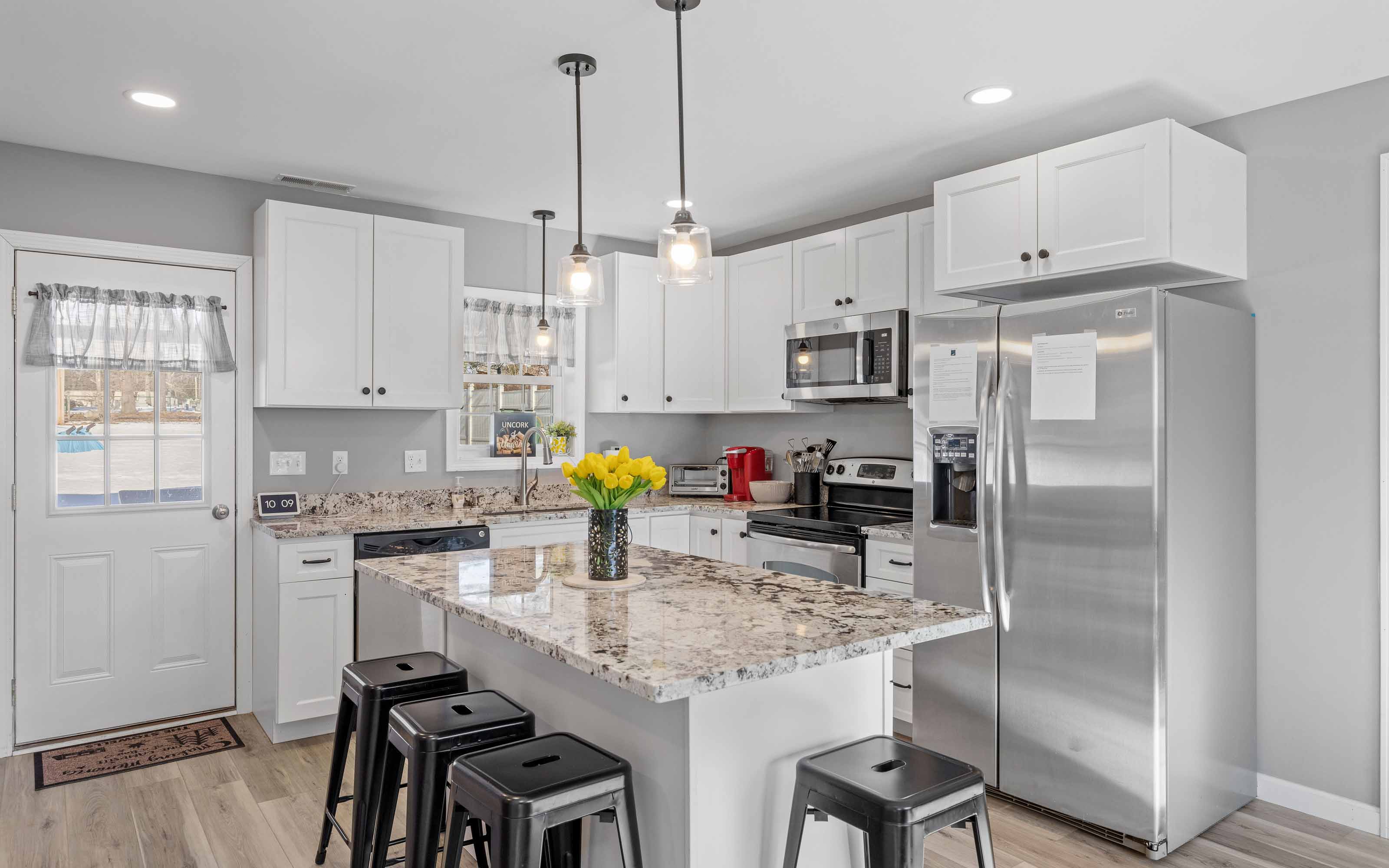 Modern kitchen with white cabinets, granite countertops, and stainless steel appliances