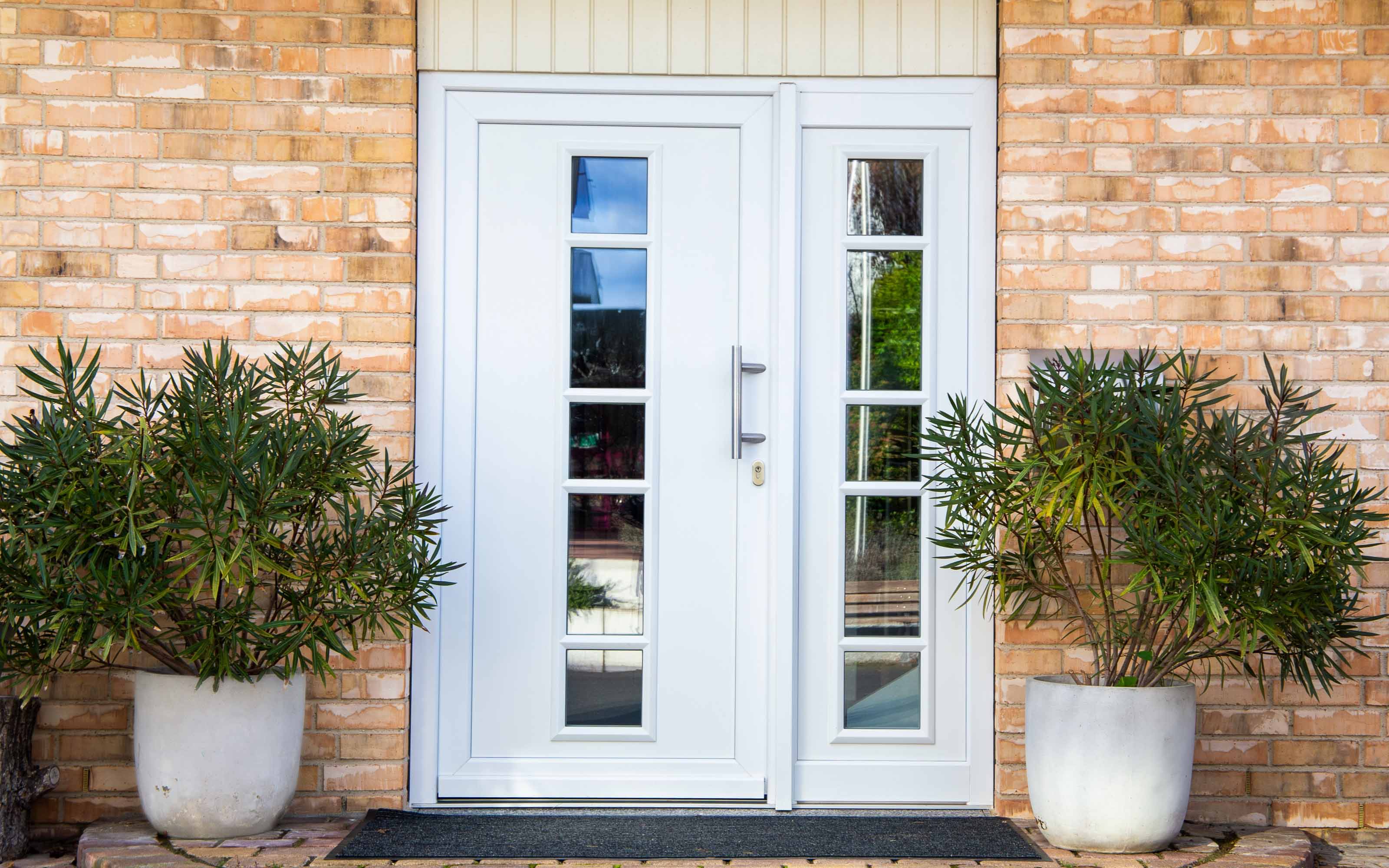 White fiberglass entry door with decorative glass inserts and matching sidelights