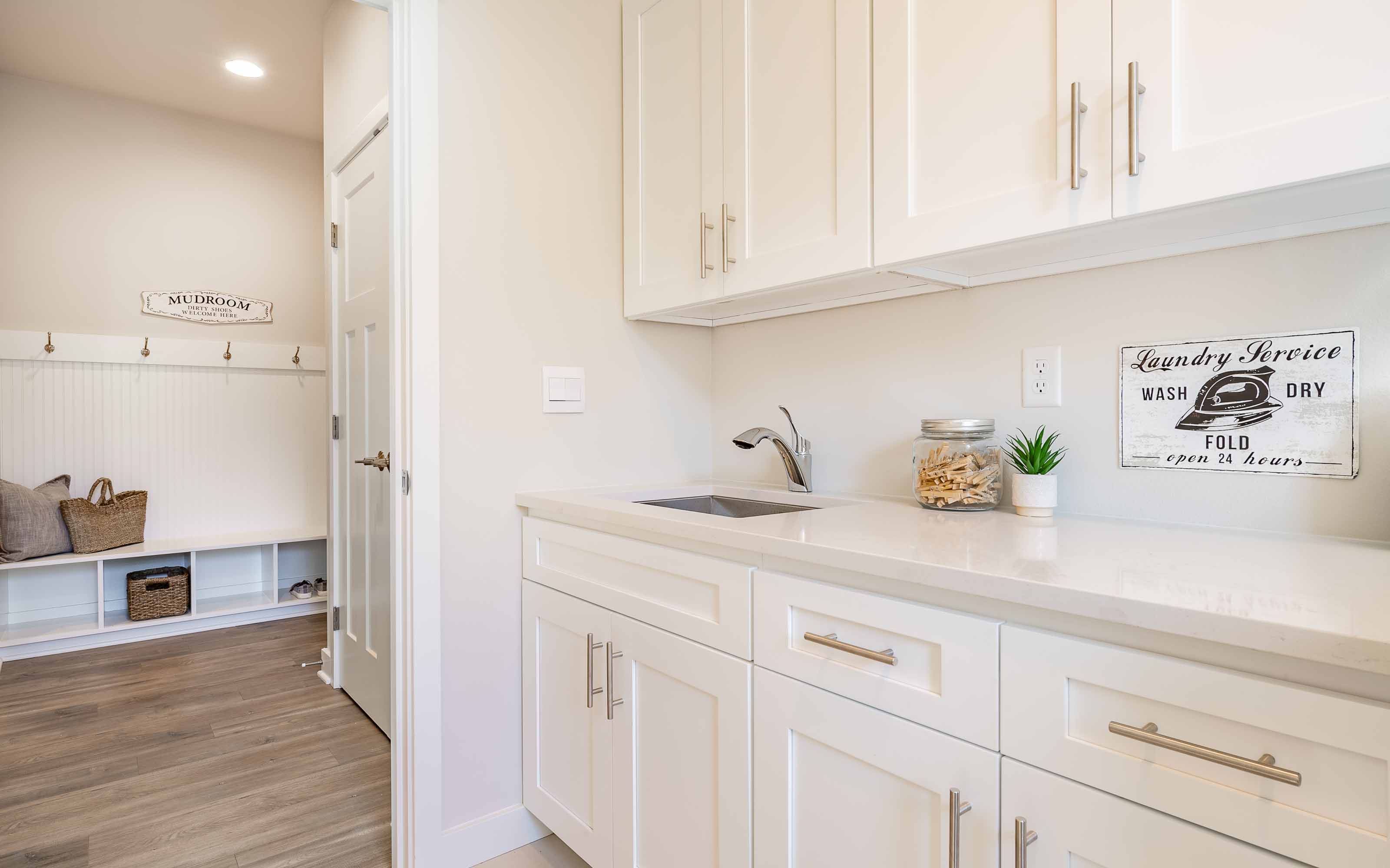 White framed kitchen cabinets in a bright modern laundry room
