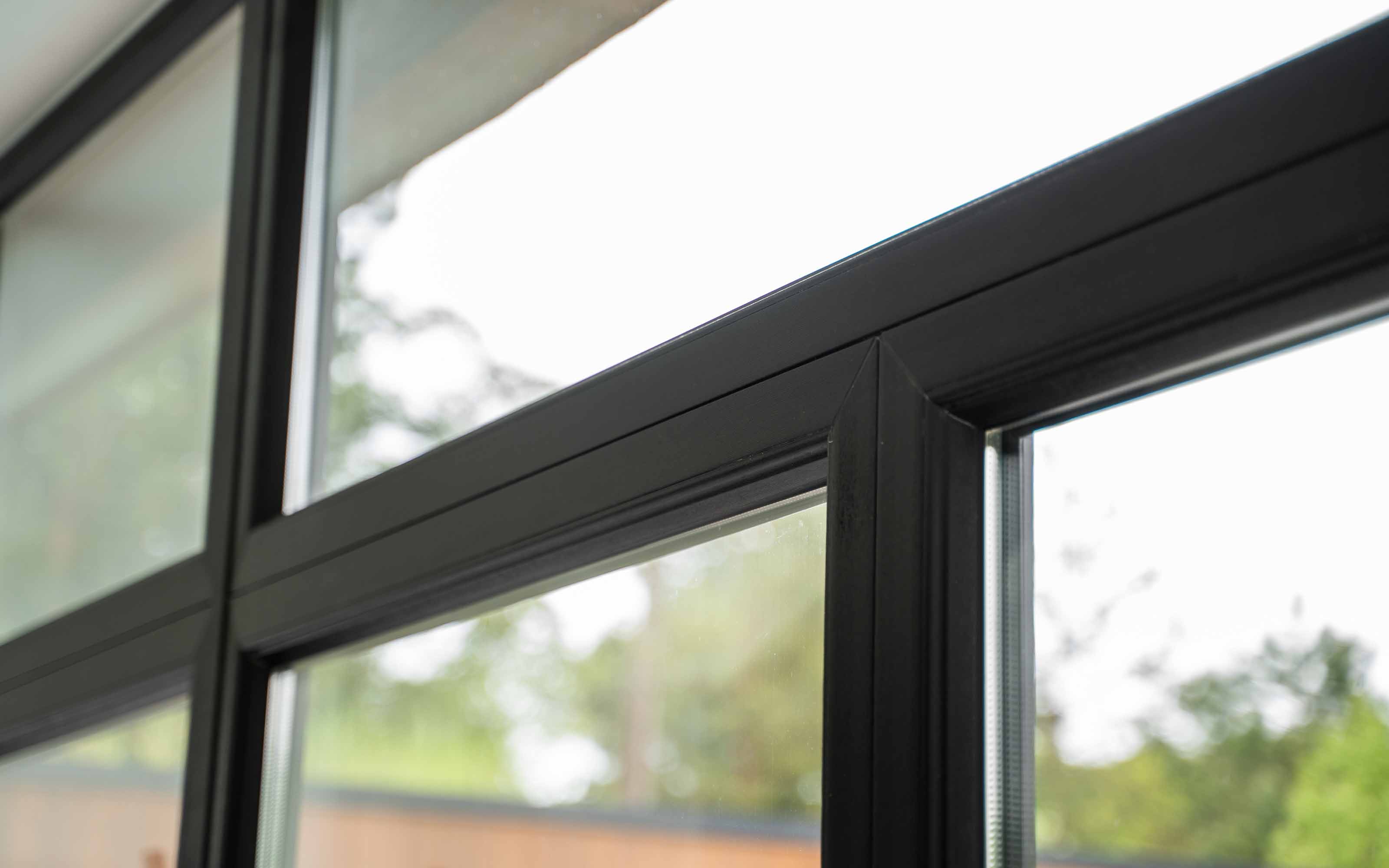 Black vinyl windows on a modern white home exterior