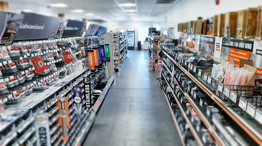 Hardware store aisle with shelves of fasteners and tools
